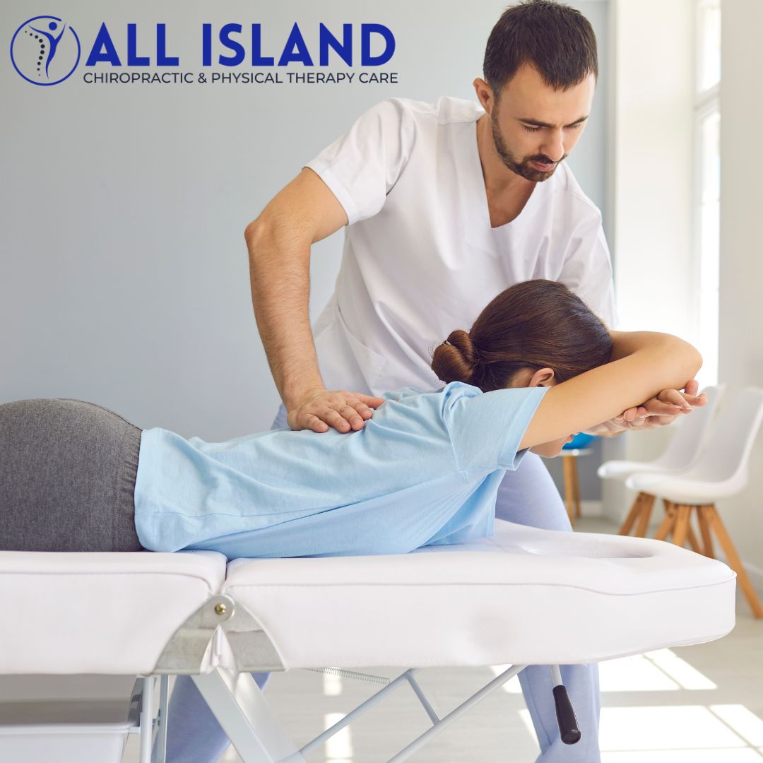 A chiropractor adjusts a patient's back on a treatment table in a clinic setting. Logo reads: "All Island Chiropractic & Physical Therapy Care.
