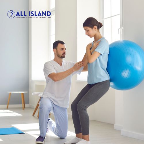 Untitled design - 2025-06-11T154949.417 A physical therapist assists a woman doing an exercise with an exercise ball against a wall in a bright, minimalistic room The All Island logo is visible in the top left corner