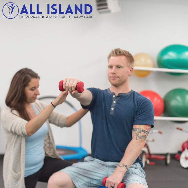 physical therapy islip (1) A physical therapist assists a seated man lifting a dumbbell in a clinic with exercise balls in the background The "All Island Chiropractic & Physical Therapy Care" logo is visible, highlighting Physical Therapy near Islip