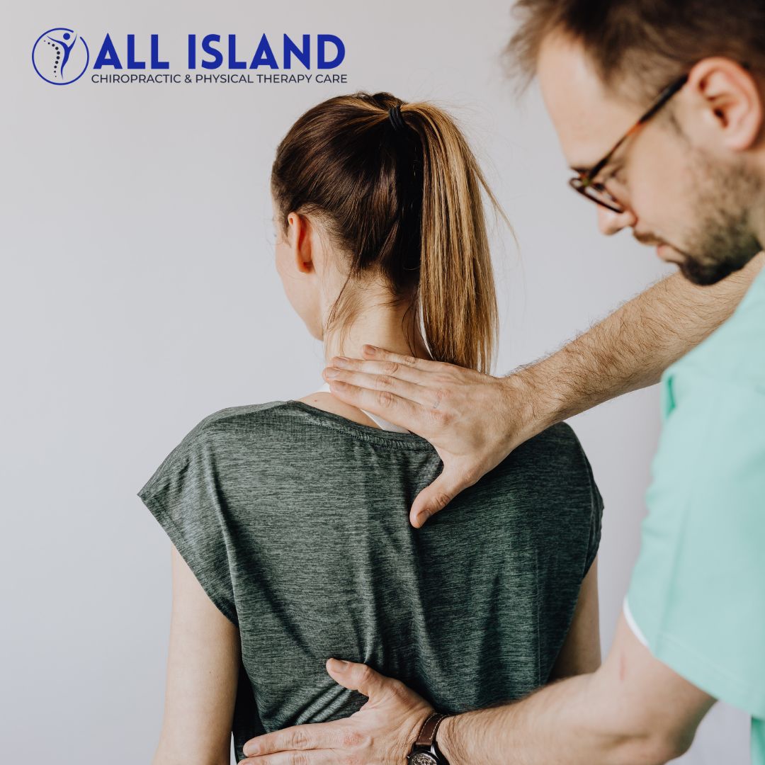 A chiropractor examines a woman's back and neck in a clinic The "All Island Chiropractic & Physical Therapy Care" logo is visible in the top left corner